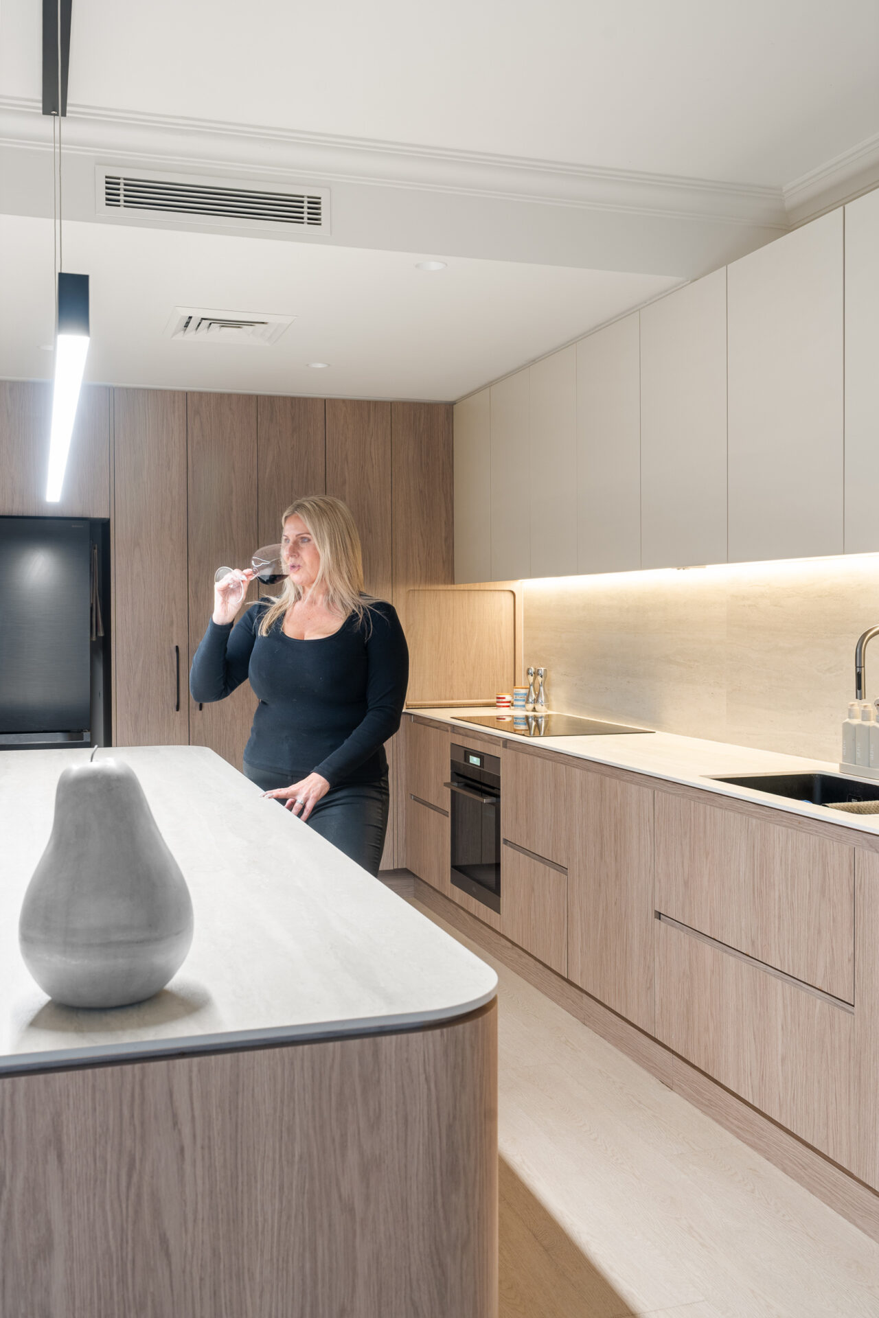 Alpine Beech hybrid flooring in a modern kitchen with woodgrain cabinetry and a stone island