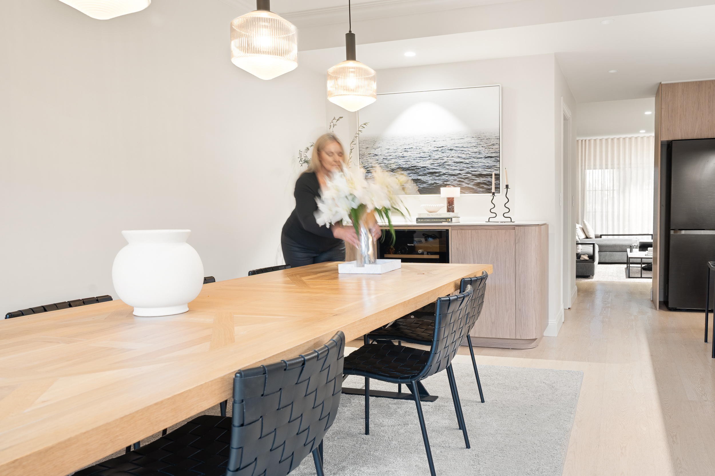 Alpine Beech hybrid flooring in a dining area with a long timber table, black woven chairs and pendant lights