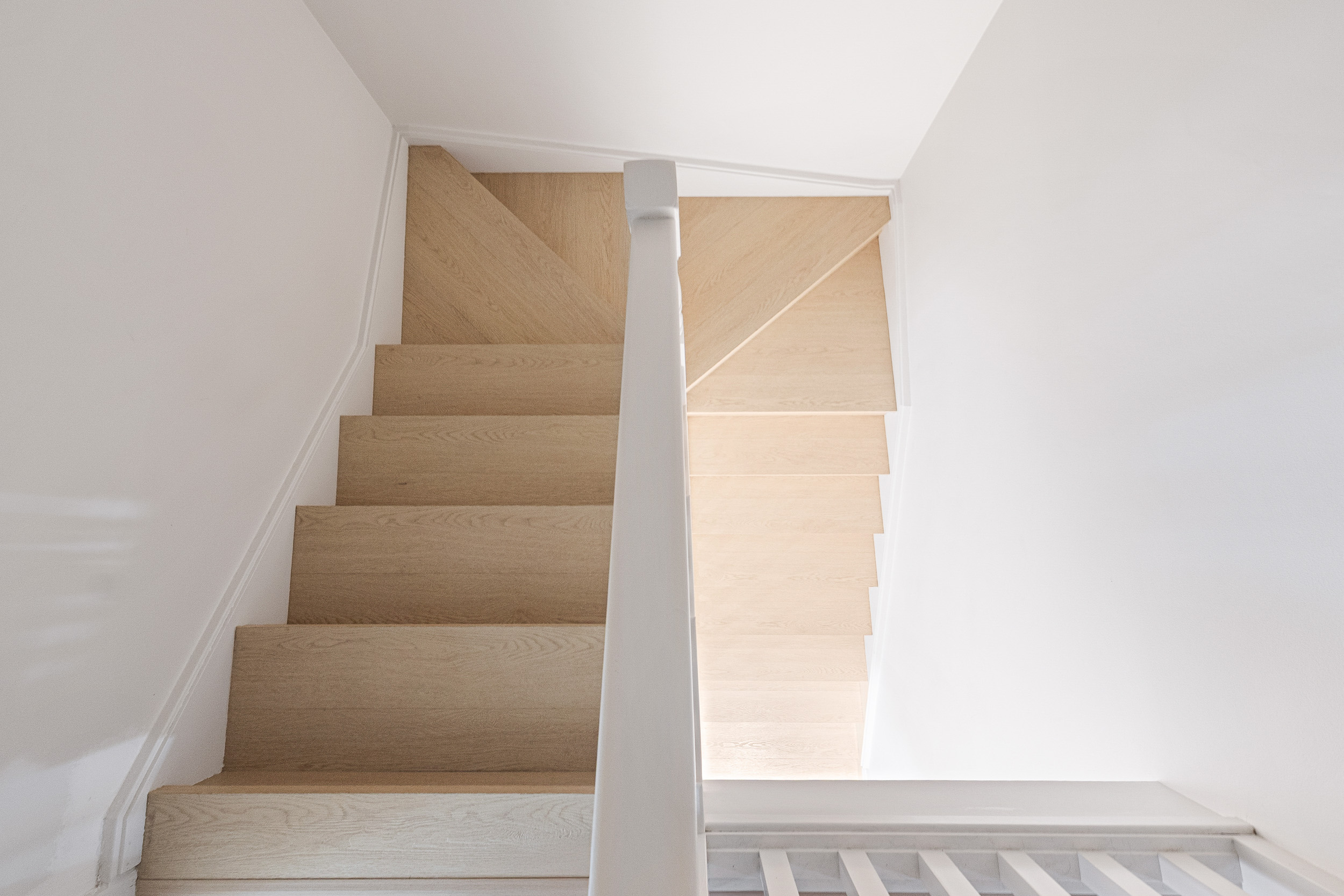 Alpine Beech hybrid flooring on a staircase with a white balustrade