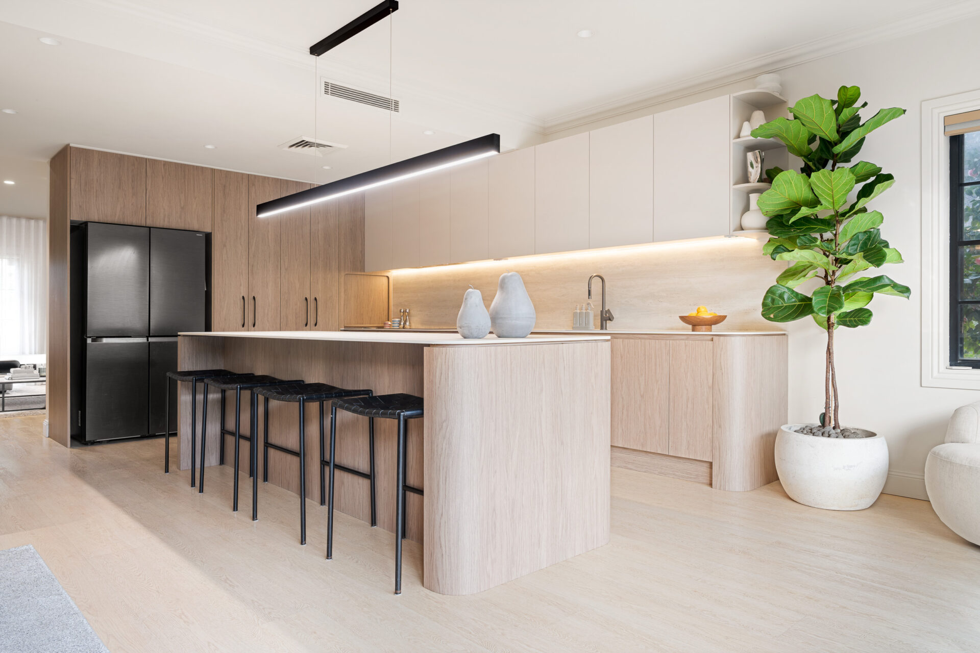 Alpine Beech hybrid flooring in an open plan kitchen with an island, bar stools and timber cabinetry
