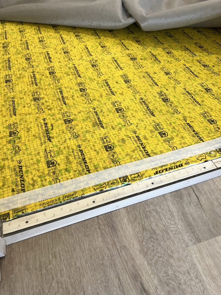 Carpet underlay layer being installed beneath new carpet