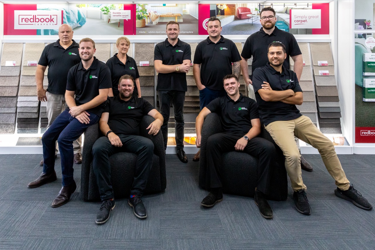 Group of Beare Flooring consultants with carpet display samples.